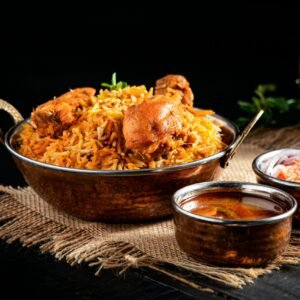From above of delicious pilaf with rice and meat in iron pan served on table near traditional oriental soups in bowl